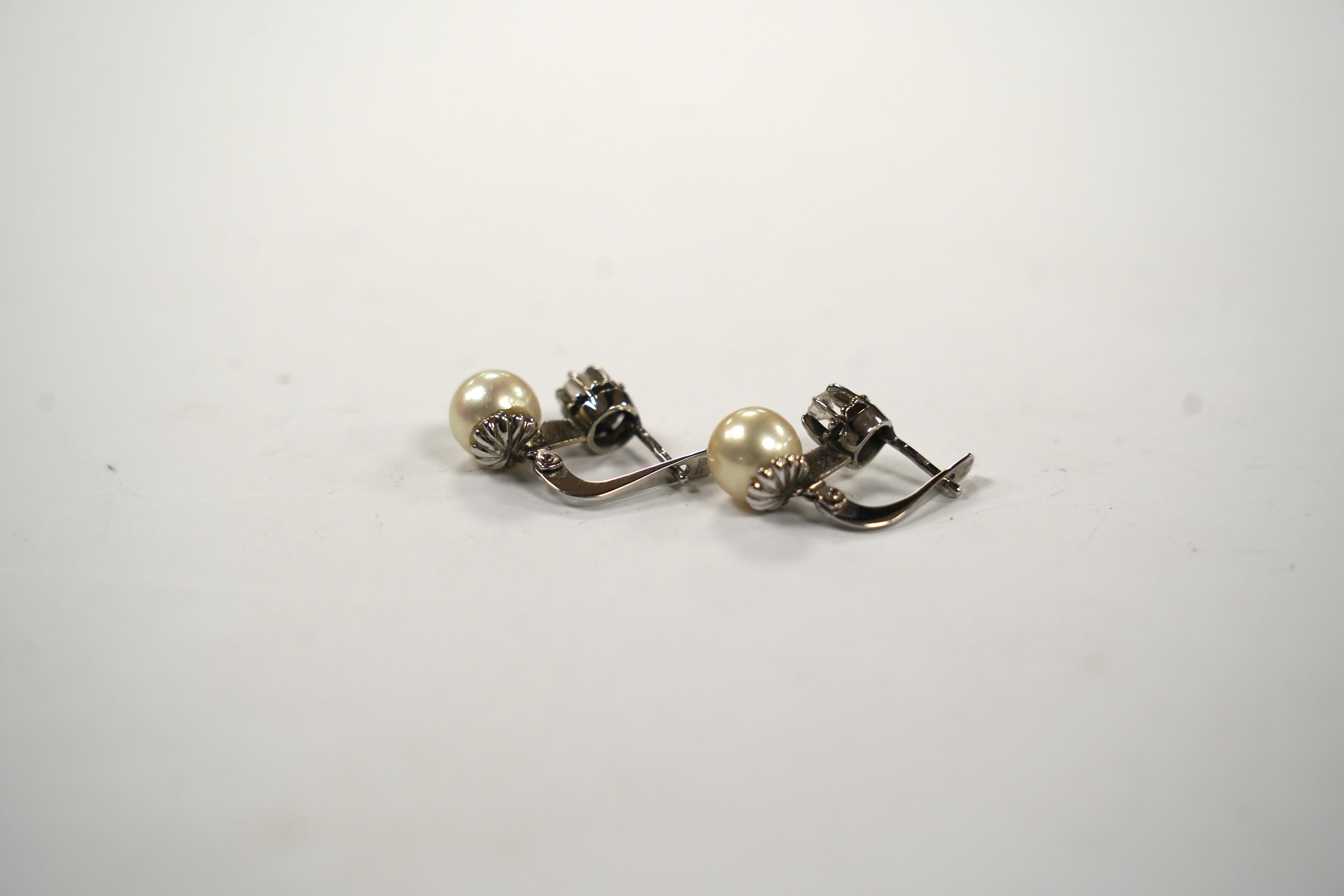 A pair of white metal, single stone cultured pearl and single stone diamond set earrings, 16mm, gross weight 4.8 grams.